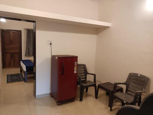 a waiting room with chairs and a red refrigerator at Deep Guest House in Arambol