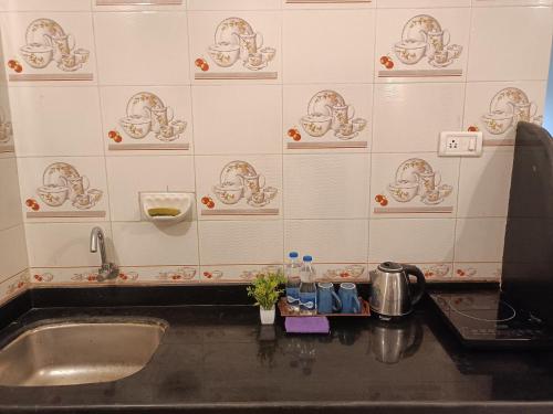 a kitchen counter with a sink in a room at Deep Guest House in Arambol