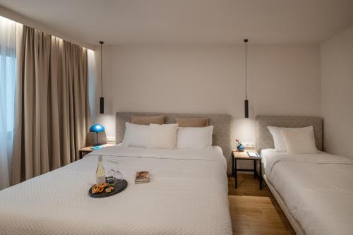 a hotel room with two beds with a tray of fruit on the bed at IRA - ΗΡΑ Hotel in Kalamata