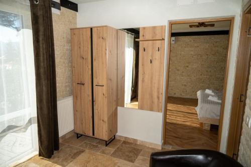 a room with a wooden cabinet and a mirror at La Brazi by BMD in Vulcan