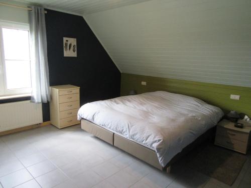 a small bedroom with a bed and a window at Sun-kissed Villa in Diksmuide with Garden, Sauna in Diksmuide