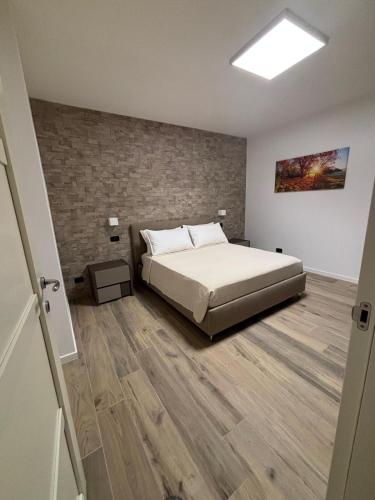 a bedroom with a bed and a brick wall at B&B Bari Apartment by Margi in Bari