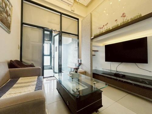 a living room with a tv and a glass table at 湯韻溫泉 in Jiaoxi
