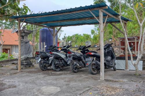 a group of motorcycles parked under a shed at Kampuak Cottages in Nusa Penida