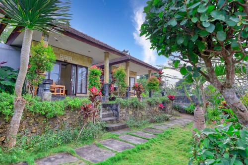 a house with a garden in front of it at Kampuak Cottages in Nusa Penida