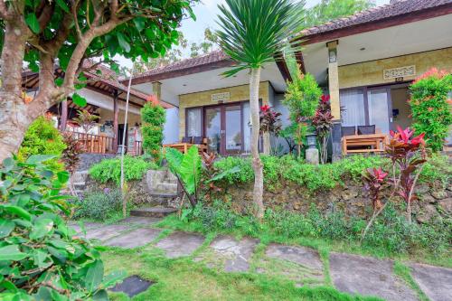 a house with a garden in front of it at Kampuak Cottages in Nusa Penida
