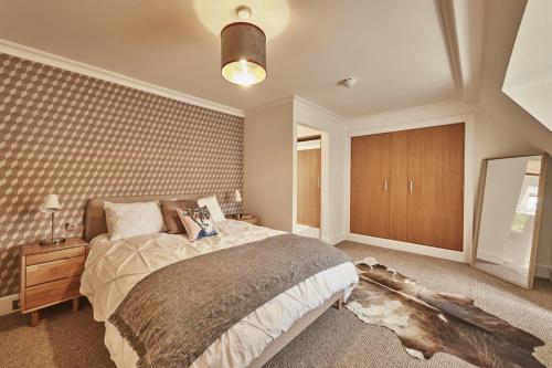 ein Schlafzimmer mit einem großen Bett und einem Spiegel in der Unterkunft The Flat - Waresley Park Estate 