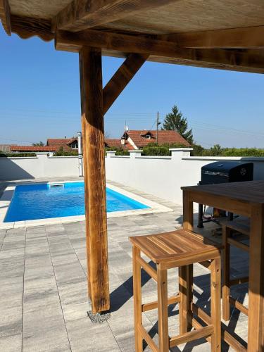 a patio with a table and a bench and a pool at Holiday House Renata in Kutina