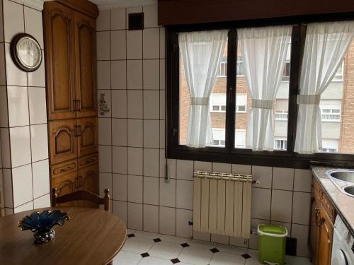 a kitchen with a wooden table and a window at El COTO - VUT 6639 AS in Gijón