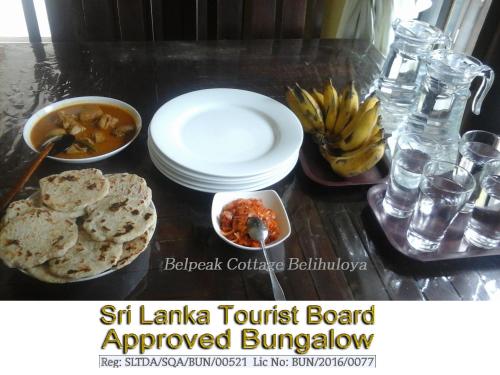 een tafel met borden en kommen met voedsel bij Belpeak Cottage in Belihul Oya