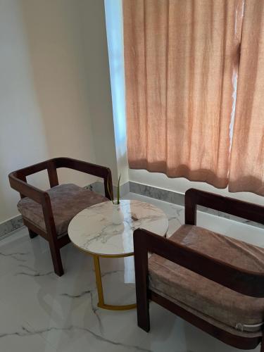 a room with two chairs and a table and a window at Hotel Pahuna Ghar in Nepālganj