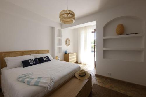a bedroom with a large white bed with blue pillows at Villa Ragona Taormina in Taormina