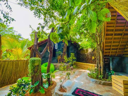a garden with a tree and a house at Elephant Lake Villa, Yoga & Meditation Sanctuary in Sigiriya
