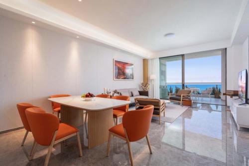 a living room with a table and chairs at Begonia Hotel in Sanya