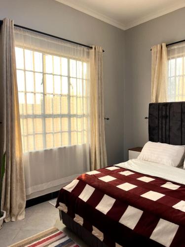 una camera da letto con un letto e una grande finestra di Sinana Escapes - Arusha ad Arusha