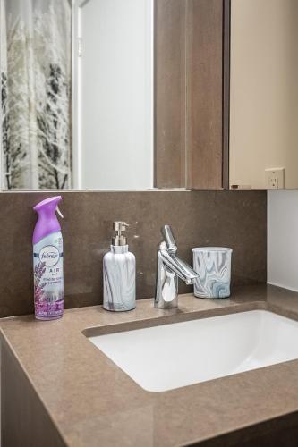 a bathroom counter with a sink and a bottle of soap at Modern 1 Bedroom Dunfield Ave Apartment in Toronto