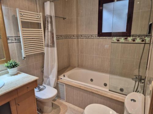 a bathroom with a tub and a toilet and a sink at PINEDO PLAYA y Garaje in Valencia