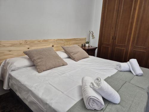 a large white bed with two pairs of towels on it at PINEDO PLAYA y Garaje in Valencia