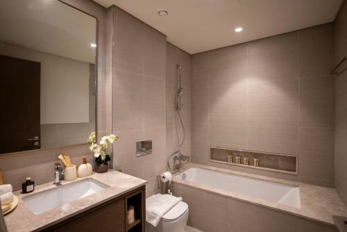 une salle de bain avec une baignoire, des toilettes et un lavabo dans l'établissement Grande Downtown Dubai - Luxury 1BR Apt near Burj khalifa and Dubai Mall, à Dubaï
