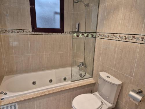 a bathroom with a toilet and a shower and a tub at PINEDO PLAYA y Garaje in Valencia