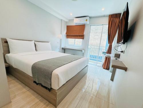 a bedroom with a bed and a tv and a window at Icon Dome Bangkok in Bangkok