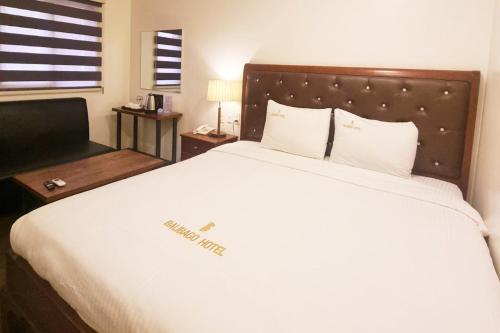 アンヘレスにあるBalibago Hotel Angeles powered by Cocotelのベッドルーム1室(白いベッドカバー付きの大型ベッド1台付)