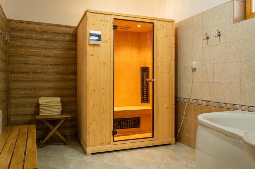a wooden shower in a bathroom with a toilet at Andrejkin dom in Blatnica