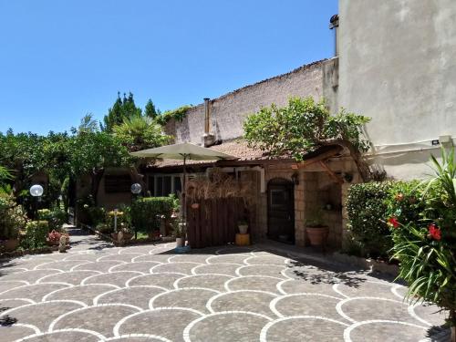 a stone walkway in front of a building with an umbrella at Residenza Caserta Sud - Appartamento con giardino in Caserta