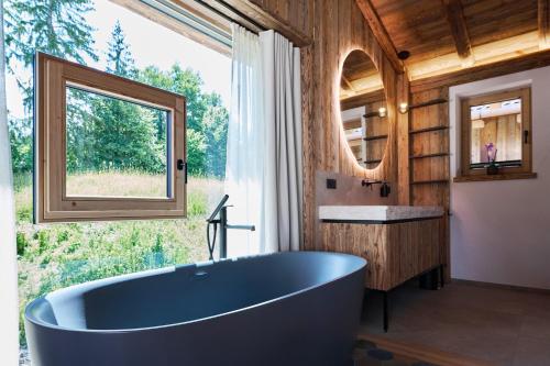 a large blue tub in a bathroom with a window at Ziegelberg Chalets in Füssen
