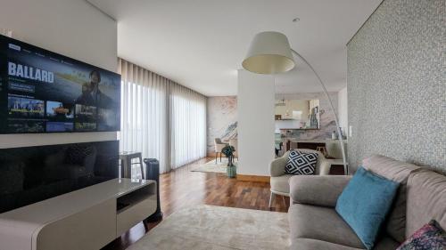 a living room with a couch and a tv at Duplex by the Beach in Ovar