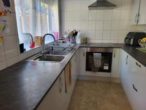 a kitchen with a sink and a dishwasher at Garden house in Canterbury