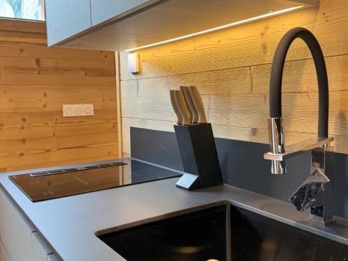 a kitchen with a sink and a knife block on the counter at Appartement Nivalis - LES GETS, en plein centre et au pied des pistes in Les Gets