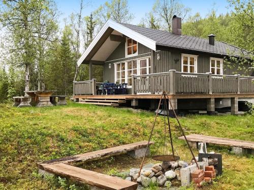 a small house with a deck and a yard at 6 person holiday home in Ballangen in Ballangen