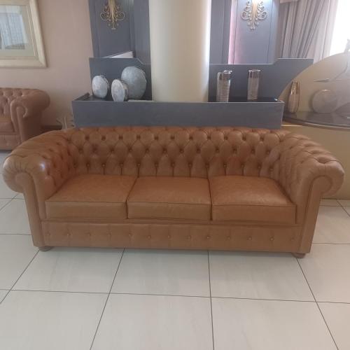 a brown couch sitting in a living room at Hotel Mondial in Marghera