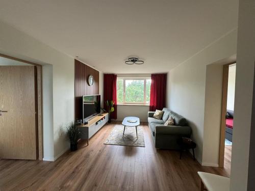 a living room with a couch and a tv at Modern apartment in Rõuge in Rõuge