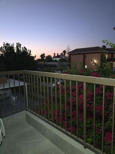 a balcony with pink flowers in front of a house at Pafos modern gem apartment margarita gardens block 6 in Paphos City