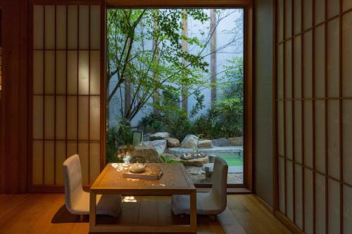 a dining room with a table and a large window at 北京一瓢客栈 Beijing YiPiao Inn in Beijing