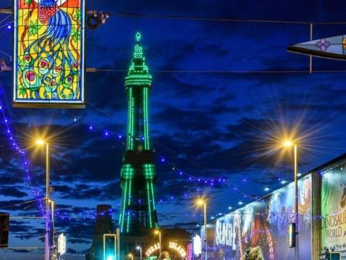 a tall green tower in a city at night at Palm Beach Hotel by the Sea in Blackpool
