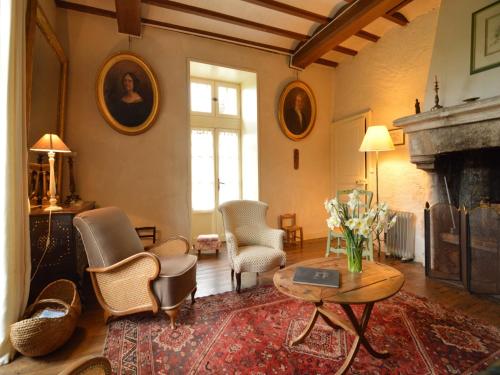 a living room with chairs and a table and a fireplace at Saint-Paul Pool Retreat in Saint-Paul-du-Bois