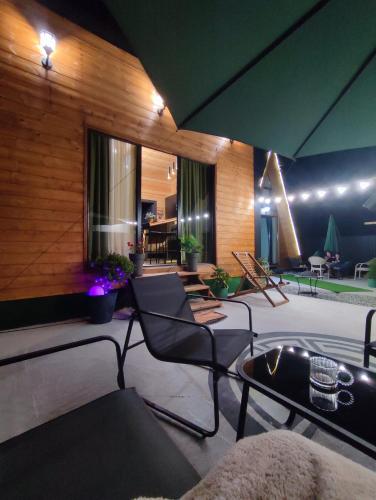 a patio with chairs and a table in a building at Wooden House Nica in Mestia
