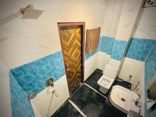 a bathroom with a toilet and a sink in it at Hotel regal garden in Faridabad