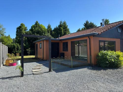a house with a gate in a gravel yard at Huisje van Hans in Ermelo
