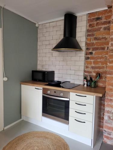 una cocina con estufa y microondas en Villa Haave, en Kotka