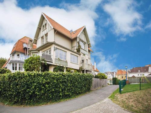een groot huis met een heg ervoor bij Holiday Home in Koksijde near Beach in Koksijde