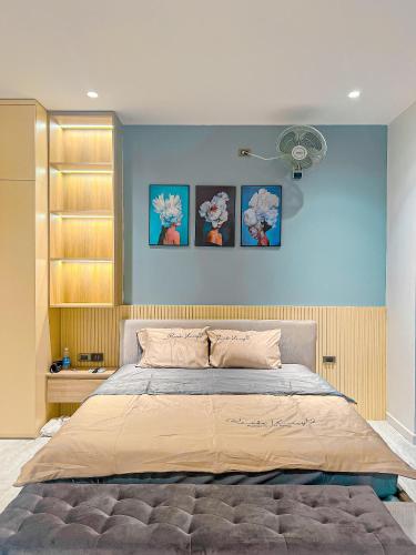 a bedroom with a bed with three pictures on the wall at Thảo Nguyên Homestay in Hanoi