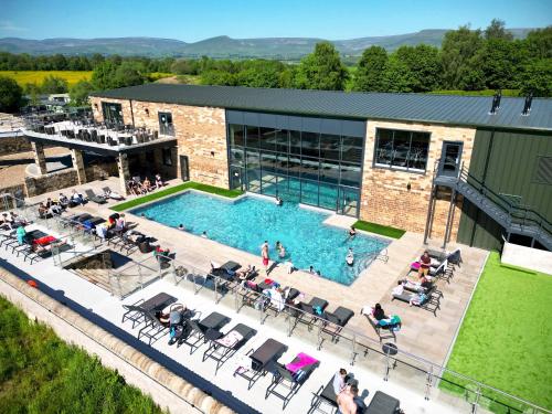 Una vista aérea de una piscina con gente sentada a su alrededor. en Wild Rose Holiday Park, en Great Ormside