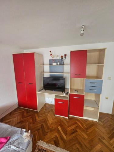 a room with red cabinets and a desk at Old Bazaar Altunalem Stay in Novi Pazar