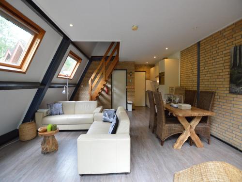 Una sala de estar con muebles blancos y una mesa de madera. en Pet-Friendly Getaway, en Stramproy