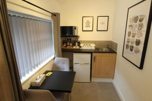 a small kitchen with a table and a sink at Anson Studios Walsall M6, J10 in Walsall