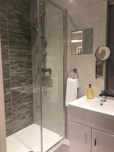 a bathroom with a glass shower and a sink at Anson Studios Walsall M6, J10 in Walsall